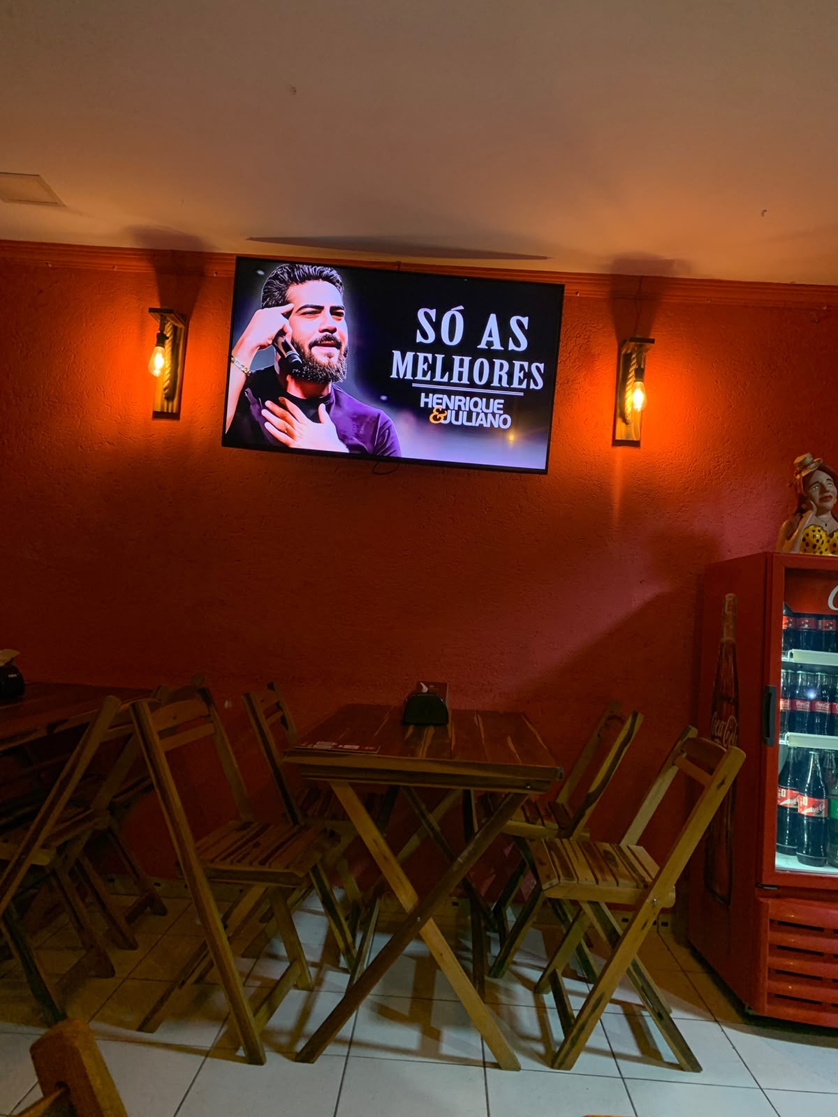 TV de bar passando uma playlist de música sertaneja do YouTube.