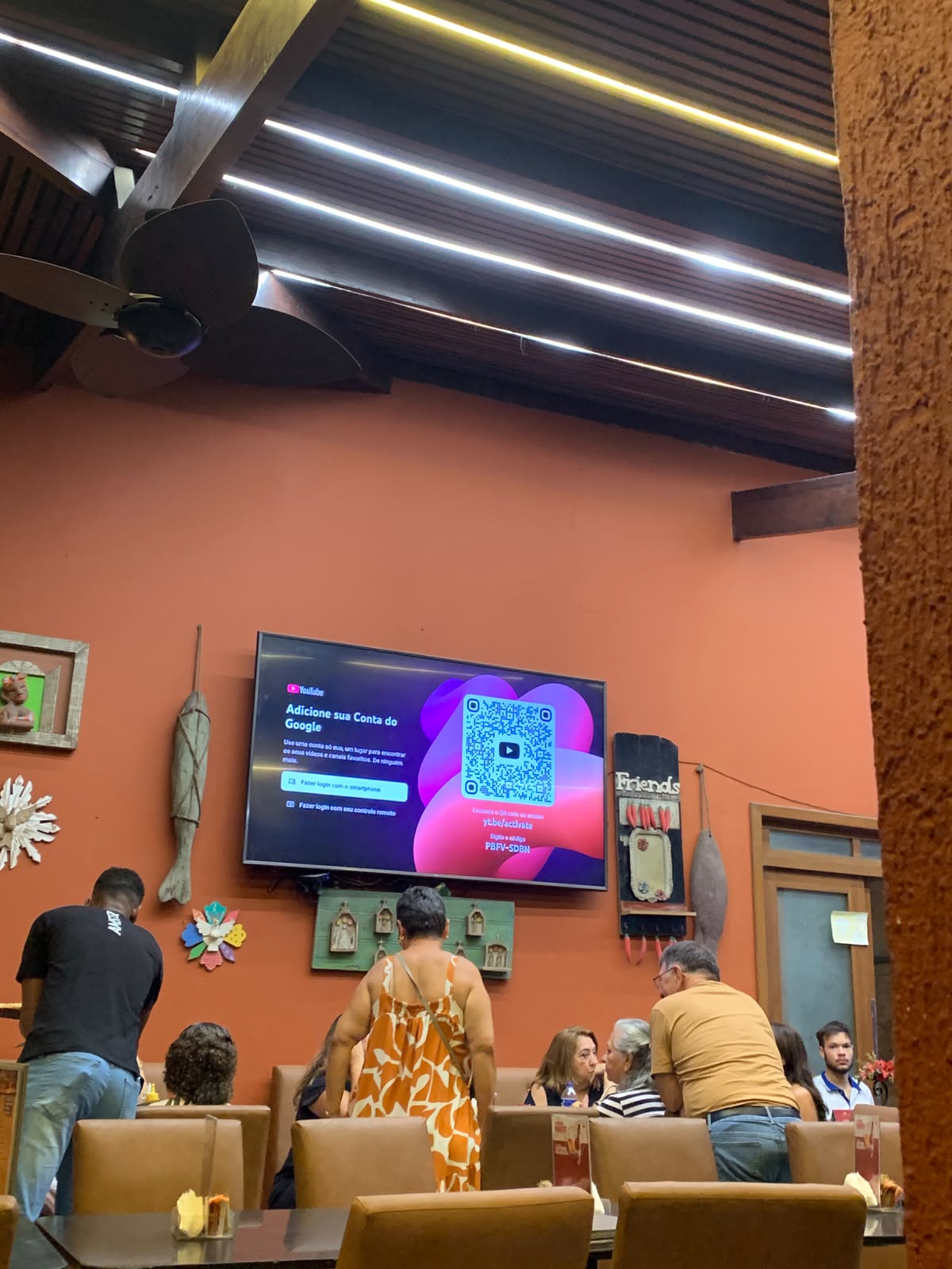 TV de um restaurante travada na tela do YouTube pedindo pra adicionar a conta do Google, na frente dos clientes.